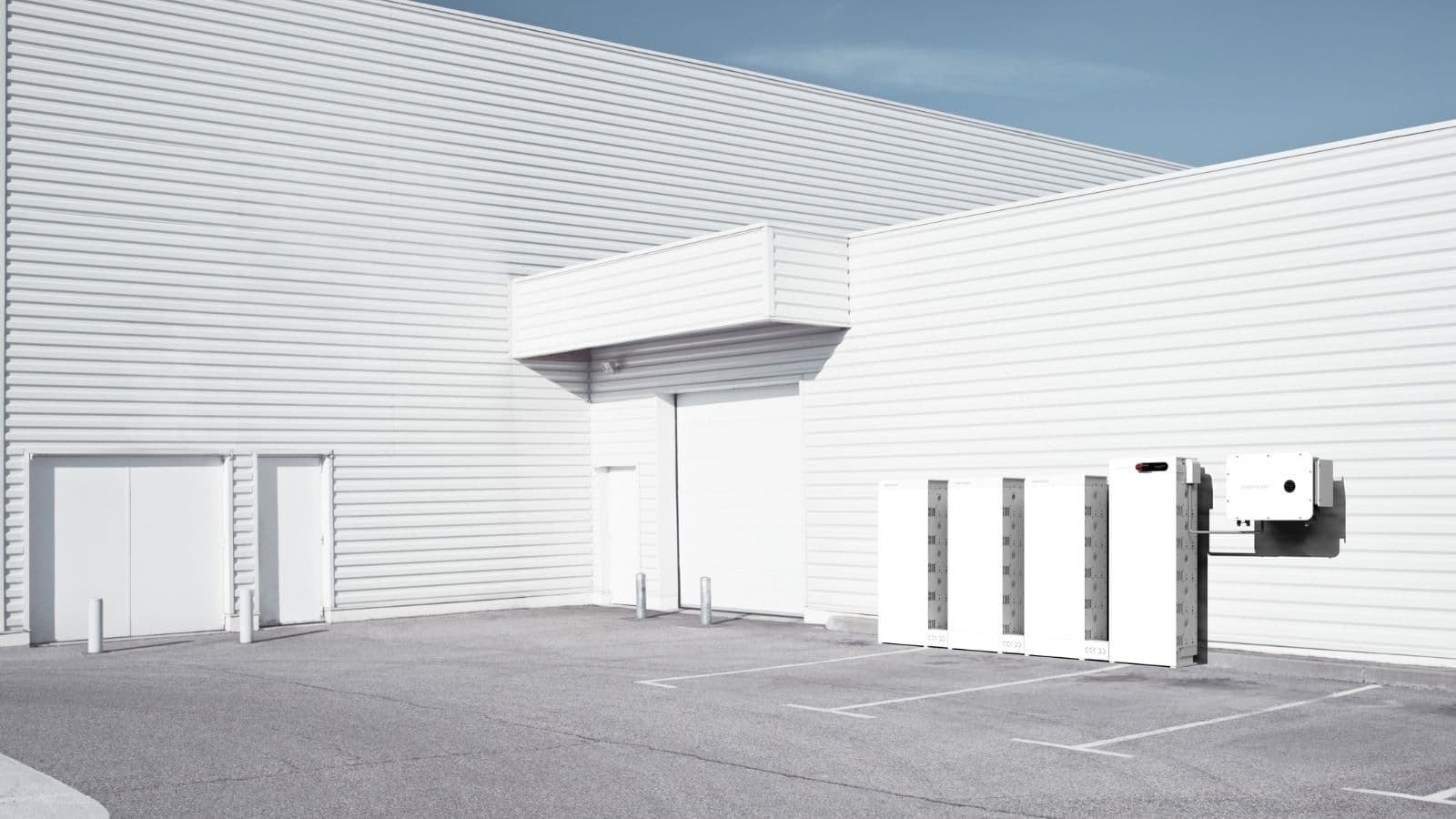 SigenStack battery cabinets and wall-mounted equipment beside a commercial building.