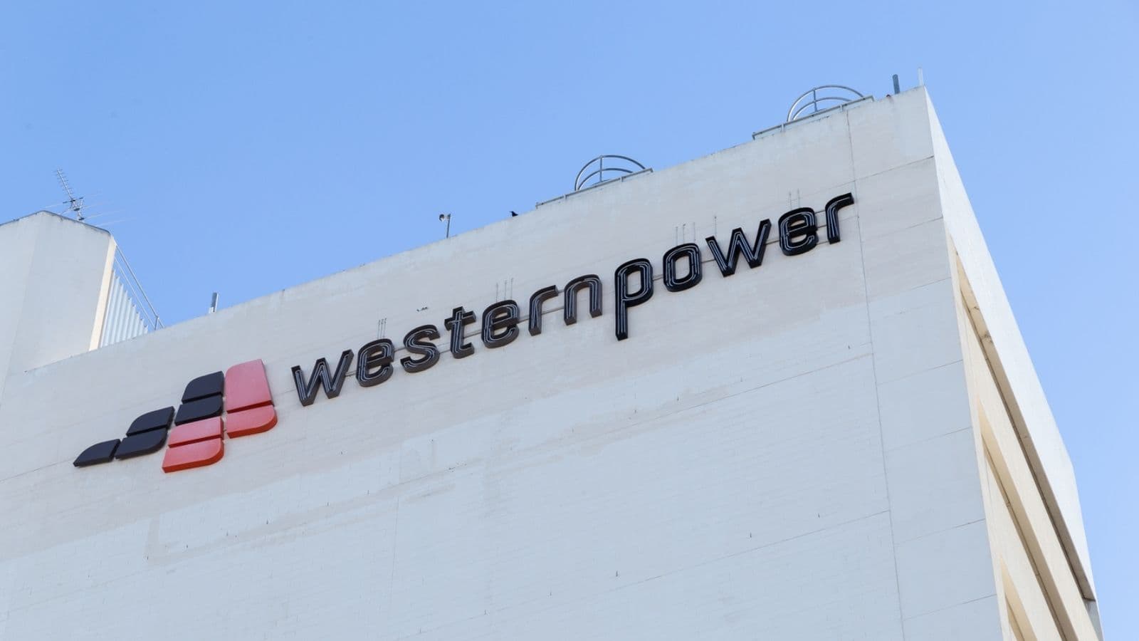 Western Power signage on a white building beneath a blue sky.